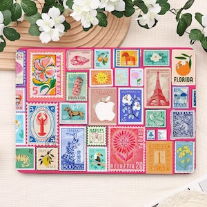 May include: A pink laptop sleeve featuring a collage of colorful postage stamps. The stamps depict various images, including flowers, landmarks, and animals. The sleeve has a rectangular shape and is designed to protect a laptop.