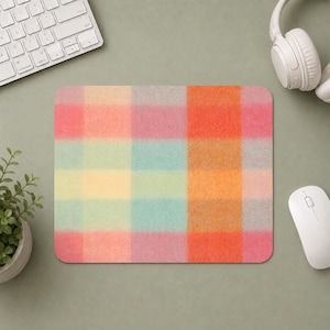 Puede incluir: Una alfombrilla de ratón rectangular con un patrón de cuadros de enfoque suave que presenta una cuadrícula de colores pastel apagados y vibrantes, incluyendo tonos naranja, rosa, amarillo, azul verdoso y gris claro, en un diseño de cuadros repetido.
