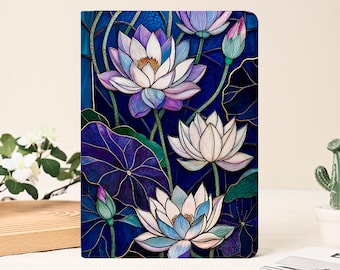 May include: A notebook with a stained-glass style lotus flower design. The cover shows white, purple, and blue lotus blossoms with green leaves against a dark blue background. The notebook is rectangular in shape.