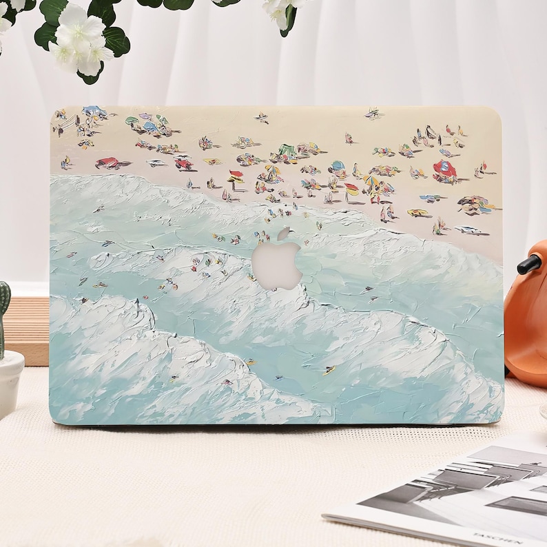 K&ouml;nnte beinhalten: Eine Laptop-H&uuml;lle mit einer impressionistischen Strandszene, mit hellblauem Ozean und Sandstrand. Das Design zeigt kleine Figuren und Sonnenschirme, mit einem Ausschnitt f&uuml;r das Apple-Logo.