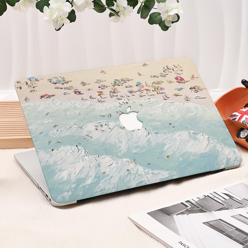 K&ouml;nnte beinhalten: Eine Laptop-H&uuml;lle mit einer k&uuml;nstlerischen Strandszene, die einen hellblauen Ozean und einen sandigen Strand zeigt. Das Design umfasst kleine Figuren von Menschen und Sonnenschirmen, mit dem Apple-Logo sichtbar.