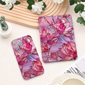 May include: A phone case and a card holder with a stained-glass effect lotus flower design in pink, purple, and white. The floral pattern is set against a soft, abstract background. The case has camera cutouts.