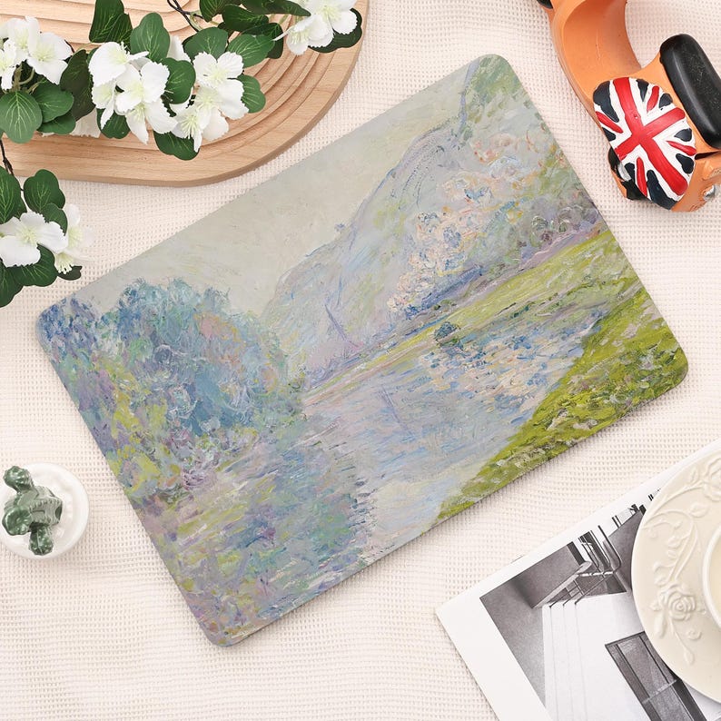 Pode incluir: Tapete de rato retangular com uma pintura de paisagem impressionista com um rio e montanhas. A obra de arte utiliza azuis, verdes e brancos, criando uma est&eacute;tica serena. O tapete &eacute; projetado para uso em computador.