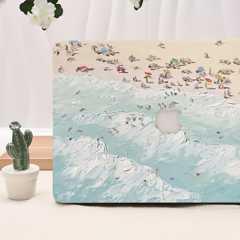 K&ouml;nnte beinhalten: Eine Laptop-H&uuml;lle mit einer impressionistischen Strandszene. Das Design zeigt einen Sandstrand mit Menschen, Sonnenschirmen und Meereswellen in Blau, Wei&szlig; und Beige. Das Apple-Logo ist sichtbar.