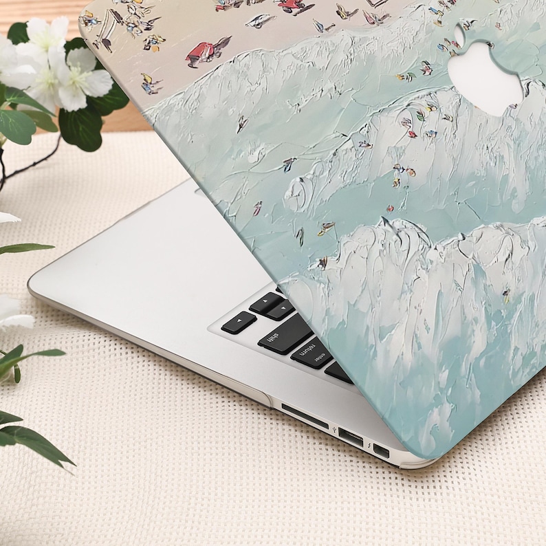 K&ouml;nnte beinhalten: Ein Laptop mit einer dekorativen H&uuml;lle, die eine abstrakte Strandszene zeigt. Die H&uuml;lle hat ein strukturiertes, gemaltes Aussehen mit hellblauen, wei&szlig;en und beigen Farben. Das Design umfasst Figuren und Wellen und schafft ein K&uuml;stenmotiv.