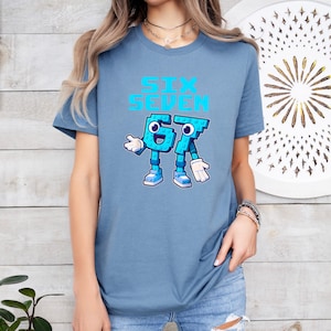 A woman wearing a blue t-shirt with a graphic design of a blue character and the text "Sex Seven" printed on it.