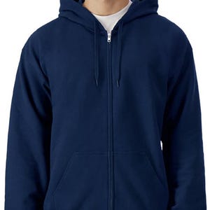 A man wearing a navy blue hooded sweatshirt with a zipper and drawstring hood.