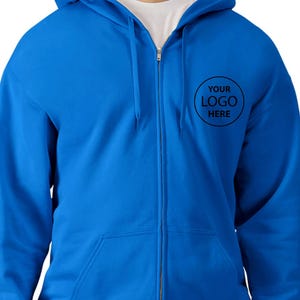 A man wearing a blue hooded sweatshirt with a logo on the front.