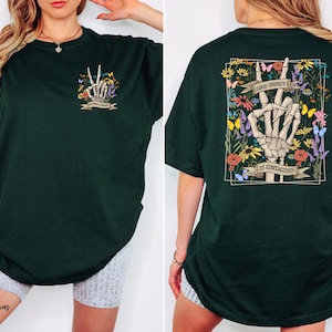 A woman wearing a green t-shirt with a graphic design on the back.