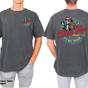 a man wearing a gray shirt with a skeleton on it