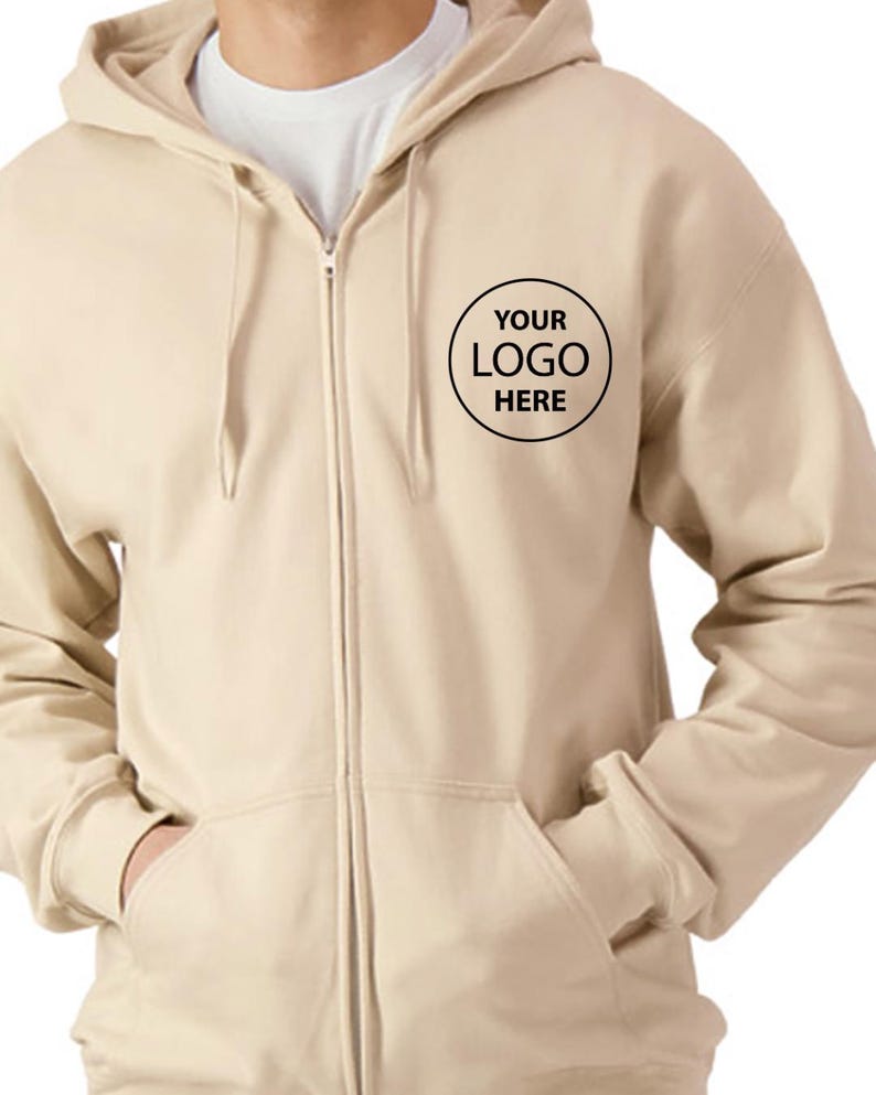 A man wearing a beige hooded sweatshirt with a black logo on the front.