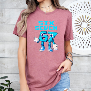A woman wearing a pink t-shirt with a graphic design of a character and text printed on it.