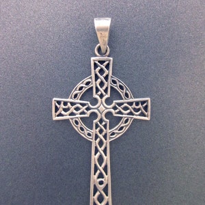 May include: A silver Celtic cross pendant with intricate knotwork design. The cross is detailed with a circle around the center.