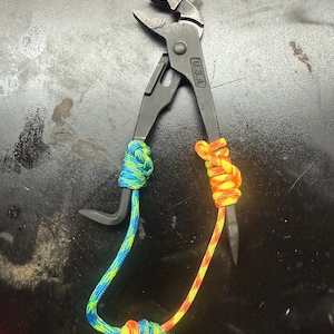 May include: Black pliers with a blue and yellow rope wrapped around the handles. The pliers have a U.S.A. marking on the side.