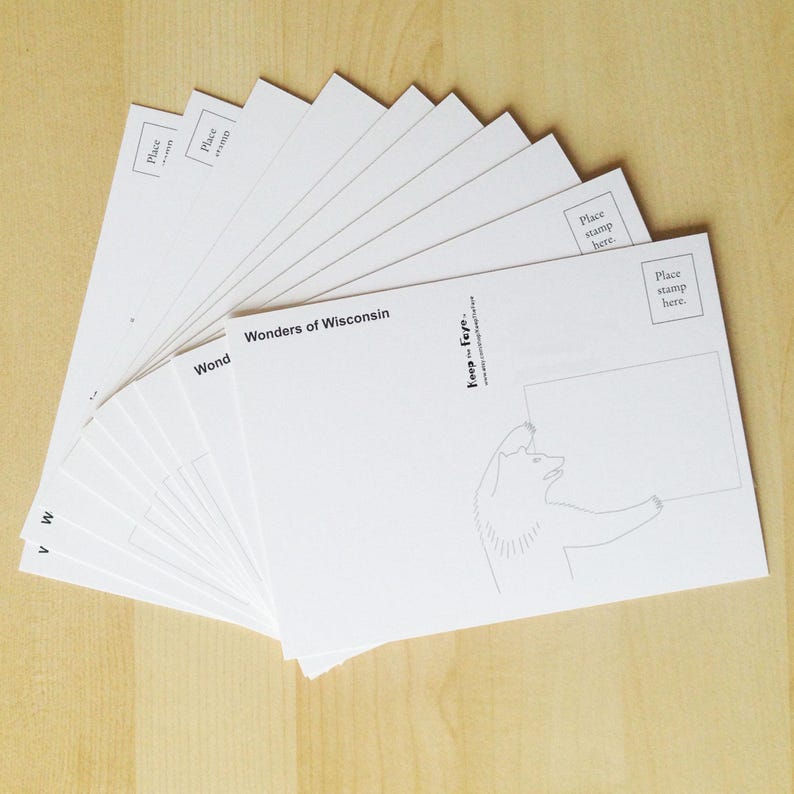 May include: A stack of white postcards fanned out, featuring the text "Wonders of Wisconsin" and a bear illustration. Each card has a space for a stamp and a blank area for a message.
