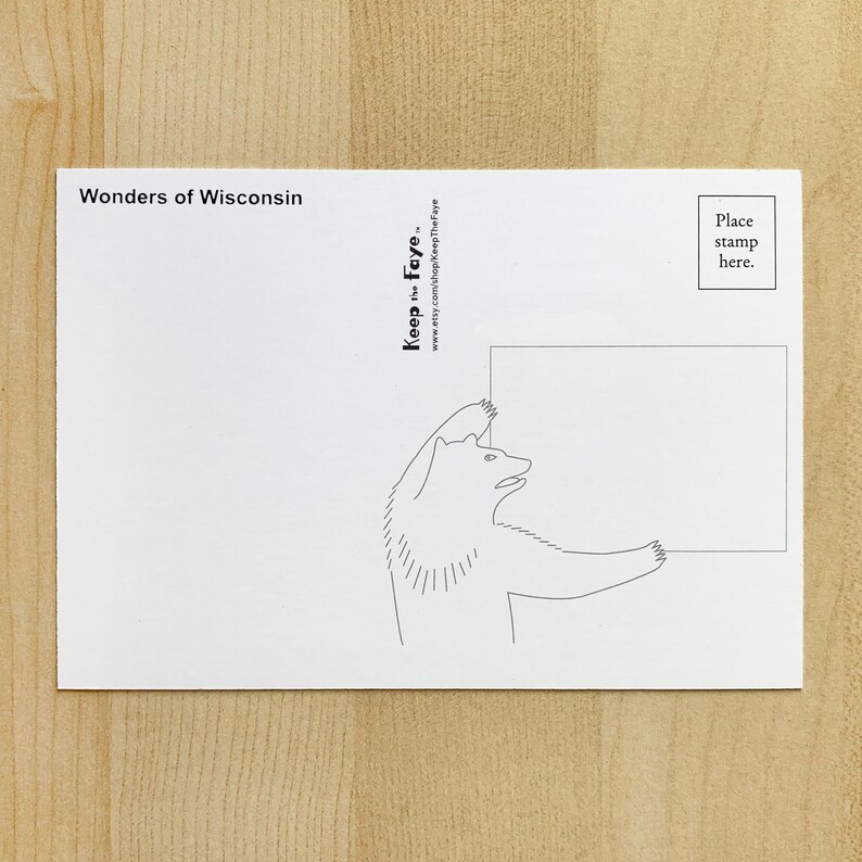May include: A white postcard with the text "Wonders of Wisconsin" at the top. A black and white illustration of a bear holding a blank rectangle is on the card. The text "Keep the Faye" and a website address are also printed on the card.