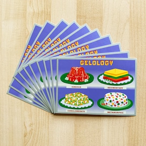 May include: A set of 10 cards with the word "Geology" printed on the front. Each card features a different type of rock: igneous, sedimentary, conglomerate, and metamorphic. Each rock is illustrated with a colorful, cartoon-like image.