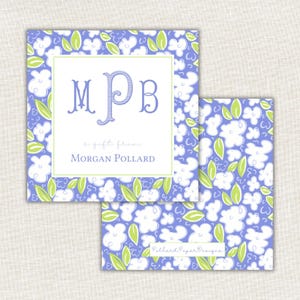 Op de afbeelding: Twee vierkante cadeaulabels met een bloemenpatroon in wit, lichtblauw en groen. Het bovenste label heeft een witte rand met de initialen "MPB" in blauw en de tekst "a gift from Morgan Pollard."