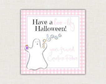 May include: A square card with a light pink and white gingham border. The center features a white ghost holding a bubble wand, blowing bubbles that form the word "boo". Text reads "Have a boo-tiful Halloween!" and "your friend Caroline Fisher".