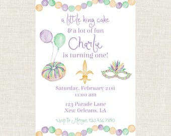 May include: A watercolor-style invitation for a first birthday party. The design includes a king cake, balloons, a fleur-de-lis, and a mask. Text reads "a little king cake & a lot of fun, Charlie is turning one!" with date, time, and address.