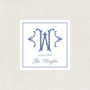 May include: A square gift tag with a blue monogram "W" and the text "A Gift From The Wrights" on a white background, framed by a blue border. The background is a light beige linen texture.
