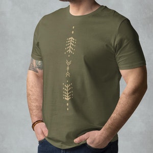Peut inclure: Un t-shirt vert avec un motif géométrique vertical beige. Le motif présente une série de triangles, de lignes et de points.