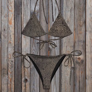 Op de afbeelding: Een tweedelige bikini met een donkerbruin en zwart slangenprintpatroon. De top is een driehoekig model met dunne bandjes om in de nek en op de rug te strikken. Het broekje heeft dunne strikbandjes aan beide zijkanten voor een verstelbare pasvorm.