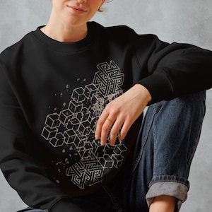 Puede incluir: Sudadera negra con un diseño geométrico de cubos y líneas blancas. El diseño tiene un efecto de pintura salpicada.
