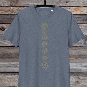 May include: A heather grey t-shirt with a vertical row of seven gold chakra symbols printed on the front.
