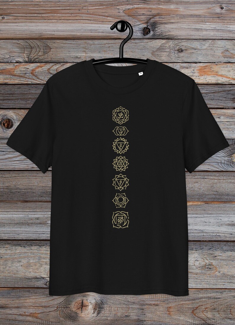 May include: Black t-shirt featuring a vertical row of seven gold chakra symbols, including the Om symbol at the top.
