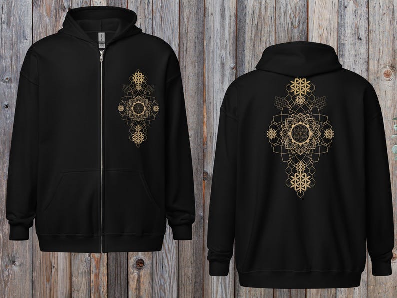 May include: Black zip-up hoodie featuring a gold geometric design on the front and back. The design includes floral and snowflake-like patterns. The hoodie has a hood, a full-length zipper, and a kangaroo pocket.