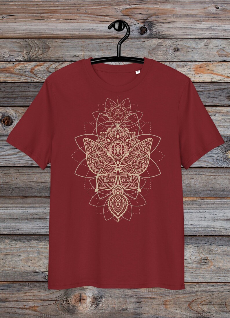 May include: A maroon t-shirt with a gold mandala design featuring a butterfly and geometric patterns.