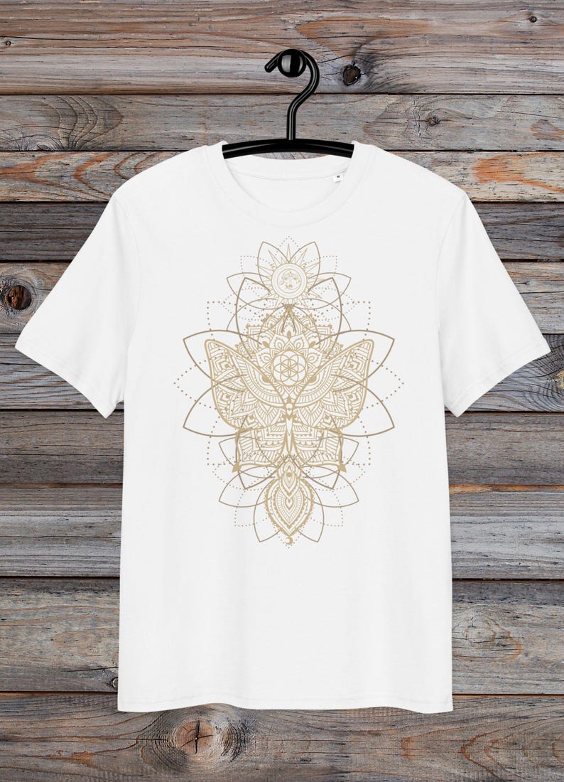 May include: White t-shirt with a gold mandala design featuring a butterfly and geometric patterns.