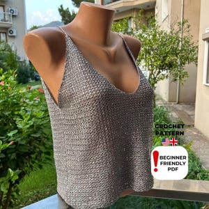 Mannequin displaying grey sequined mesh summer blouse with deep V-neckline and sparkly texture, created from intermediate crochet pattern PDF for coastal style.