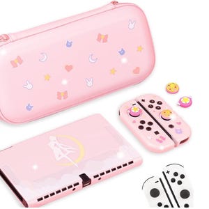 Könnte beinhalten: Rosa Nintendo Switch Tragetasche mit Sailor Moon-Motiv. Die Tasche hat ein rosa-weißes Design mit Sternen, Monden und Herzen. Die Tasche enthält außerdem eine rosa-weiße Controller-Haut, einen rosa-weißen Displayschutz und einen Satz rosa-weißer Joy-Con-Griffe.
