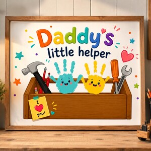 May include: A framed artwork with the text "Daddy's little helper" and a toolbox design. The artwork features cartoon handprints, tools, and a note that says "I love you!" in a heart shape. The frame is brown.