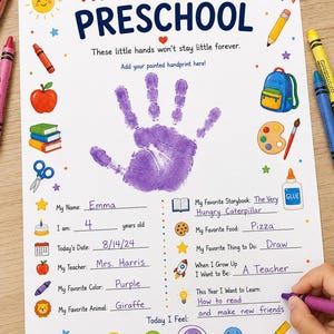 May include: A white paper sheet titled My First Day of Preschool with a purple handprint in the center. It features colorful illustrations of school supplies, a space for personal details, and a section to circle feelings, filled out with blue ink.