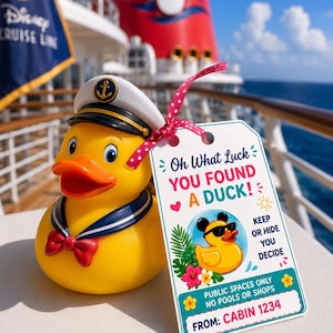Może przedstawiać: Żółta gumowa kaczka w czapce marynarskiej, granatowym kołnierzu i czerwonej muszce. Etykieta głosi "Oh What Luck YOU FOUND A DUCK!" z kreskówkową kaczką w okularach przeciwsłonecznych. Tło przedstawia pokład statku wycieczkowego i ocean.