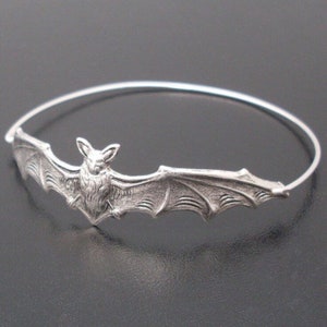 Pu&ograve; includere: Un braccialetto rigido in argento con un designo di pipistrello dettagliato. Il pipistrello &egrave; centrato sul braccialetto e ha le ali che si estendono fino ai bordi del braccialetto.