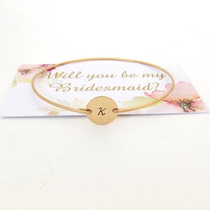 Puede incluir: Pulsera de oro para propuesta de dama de honor con un dije redondo grabado con la letra "K" y una tarjeta que dice "&iquest;Quieres ser mi dama de honor?"