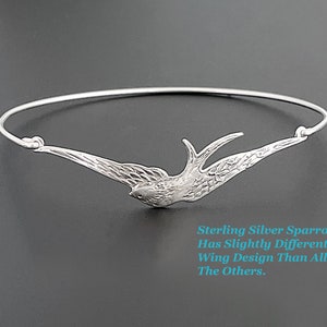 Pu&ograve; includere: Un braccialetto rigido in argento sterling con un motivo a passero. L'uccello &egrave; raffigurato in volo, con le ali spiegate. Il testo nell'immagine recita: "Sterling Silver Sparrow Has Slightly Different Wing Design Than All The Others."