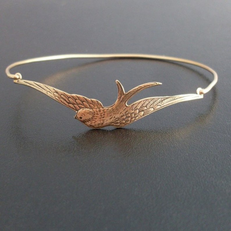 Pu&ograve; includere: Un braccialetto rigido color oro con un uccello dettagliato in volo. L'uccello ha le ali spiegate e dettagli intricati delle piume. Il braccialetto &egrave; un design semplice ed elegante, perfetto per l'uso quotidiano.