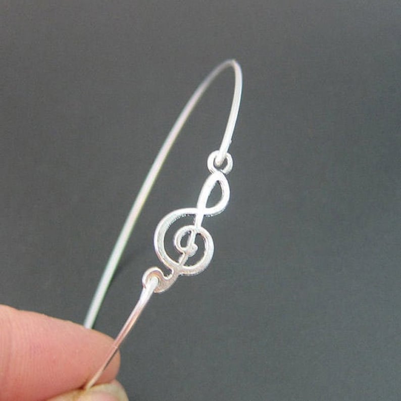 May include: A silver bracelet with a treble clef charm.