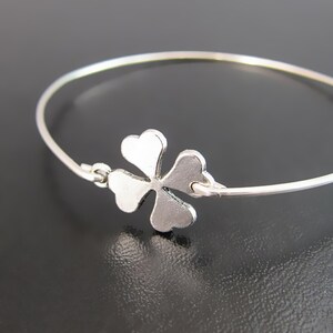 May include: A silver bracelet with a four-leaf clover charm.