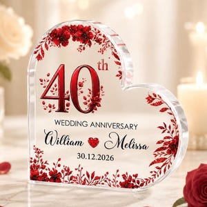 May include: A heart-shaped clear acrylic plaque featuring red floral accents and the text 40th WEDDING ANNIVERSARY, the names William and Melissa separated by a red heart icon, and the date 30.12.2026 printed in black and red lettering.