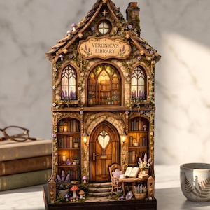 May include: A miniature wooden library building with a peaked roof, stone-textured walls, and illuminated windows. The sign above the entrance reads VERONICA'S LIBRARY. The structure features shelves filled with books, a central arched door, and small potted plants, all set on a dark rectangular base.