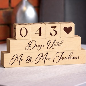 May include: A wooden wedding countdown block set. The top row of blocks displays the numbers "0 4 3" and a heart symbol. The middle block reads "Days Until" and the bottom block reads "Mr & Mrs Johnson".