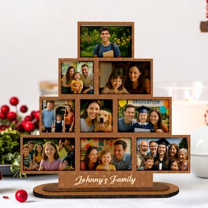 May include: A wooden family photo display with multiple rectangular frames arranged in a tiered design. The frames hold various family photos. The base of the display is engraved with the text "Johnny's Family".