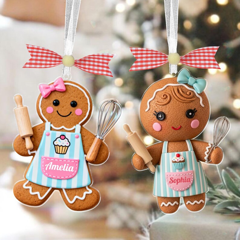 May include: Two gingerbread cookie ornaments with white ribbon hangers and red and white checkered bows. Each ornament has a pink bow, a blue and white striped apron, and holds a rolling pin and whisk. One apron says "Amelia", the other says "Sophia".