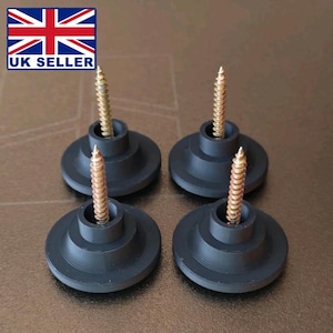 Puede incluir: Cuatro patas de muebles negras con tornillos dorados. Cada pata tiene una base circular con un diseño escalonado. Los tornillos se insertan en el centro de cada pata. La imagen incluye un logotipo de UK Seller.